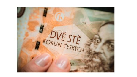 Ženské ruce drží bankovku 200 Kč